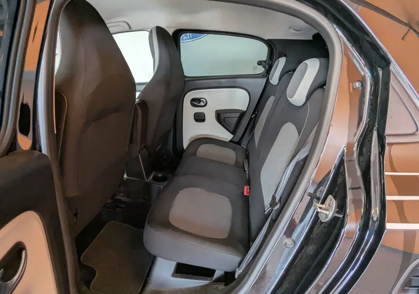 Vue intérieure côté droit des sièges arrière gris et noir d'une Renault Twingo III noire avec porte arrière ouverte.