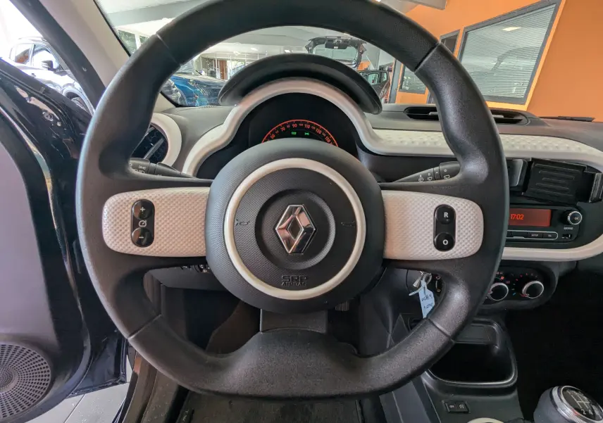 Vue rapprochée du volant noir et beige de la Renault Twingo III 2019, avec tableau de bord et commandes visibles.