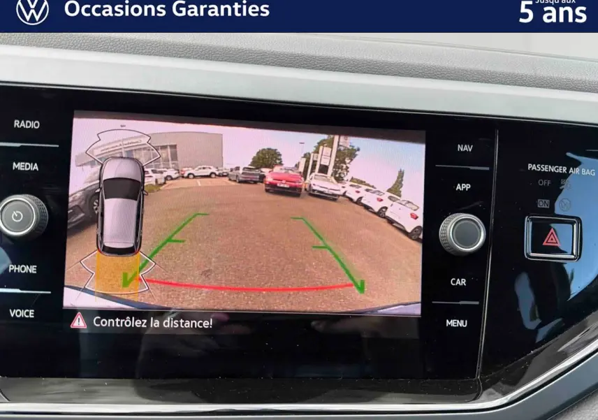 Écran tactile de la caméra de recul du Volkswagen Polo 2025, affichant l'arrière avec lignes de guidage vertes et rouges.