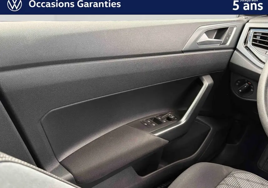 Vue intérieure côté passager avant de la Volkswagen Polo 2025 avec garniture noire et commandes des vitres intégrées.