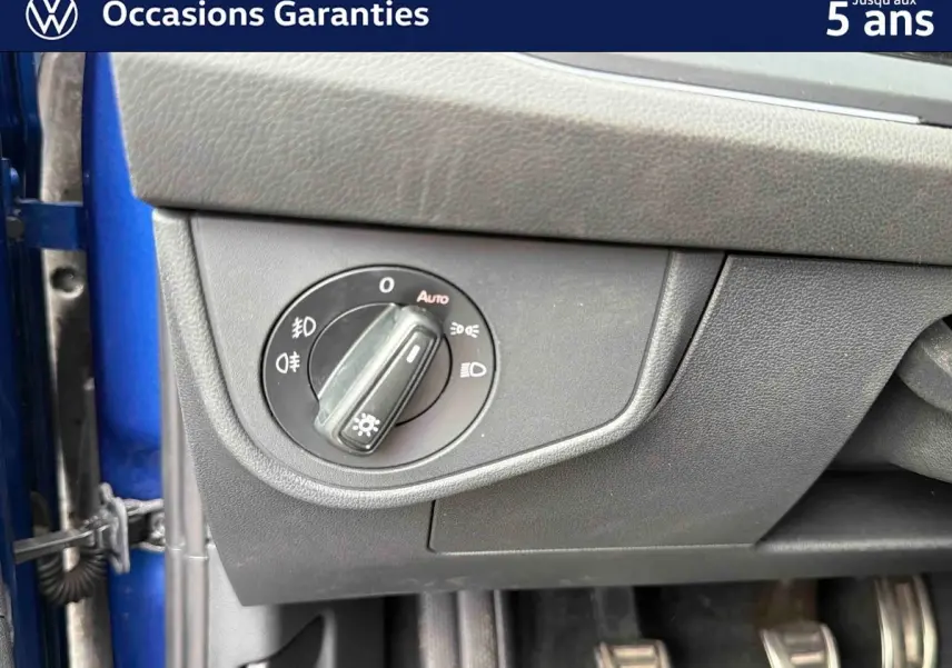 Détail du bouton de commande des phares sur le tableau de bord côté conducteur d’une Volkswagen Polo bleue 2025.