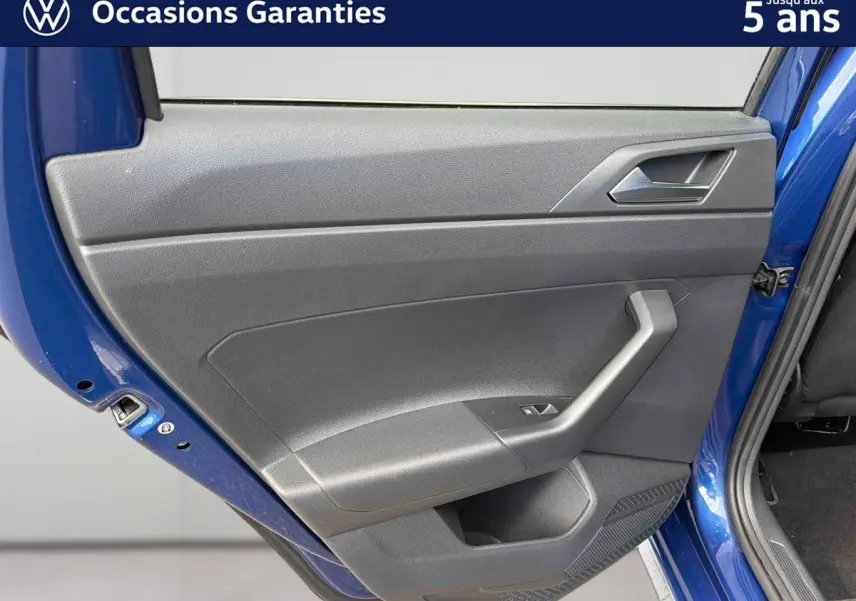 Vue rapprochée de la porte arrière gauche d’une Volkswagen Polo 2025 bleu récif avec garniture intérieure grise.