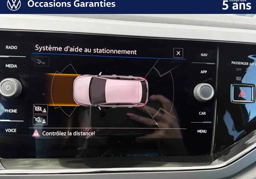 Écran tactile du système d’aide au stationnement de la Volkswagen Polo 2025 montrant une vue aérienne du véhicule.