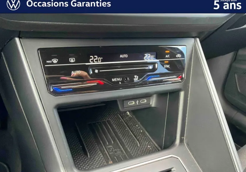 Vue rapprochée de la console centrale avec climatisation automatique tactile et ports USB d'une Volkswagen Polo bleue 2025.