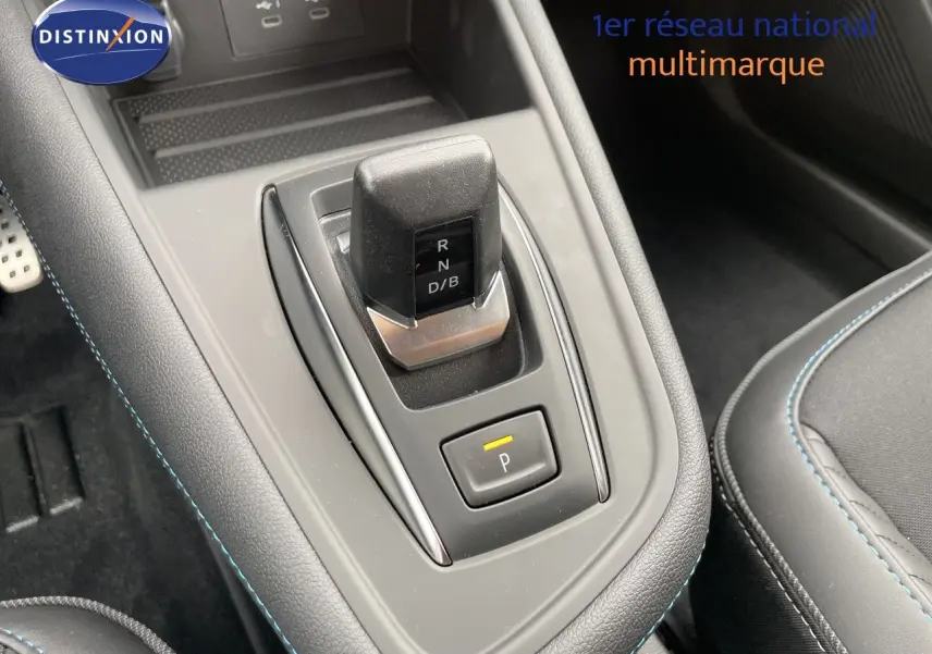 Le levier de vitesses automatique noir et gris du Renault Symbioz 2026, entouré de coutures bleues sur la console centrale.