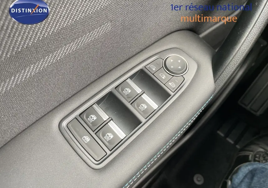 Gros plan sur les commandes des vitres électriques côté conducteur d’une Renault Symbioz gris cassiopée métal.