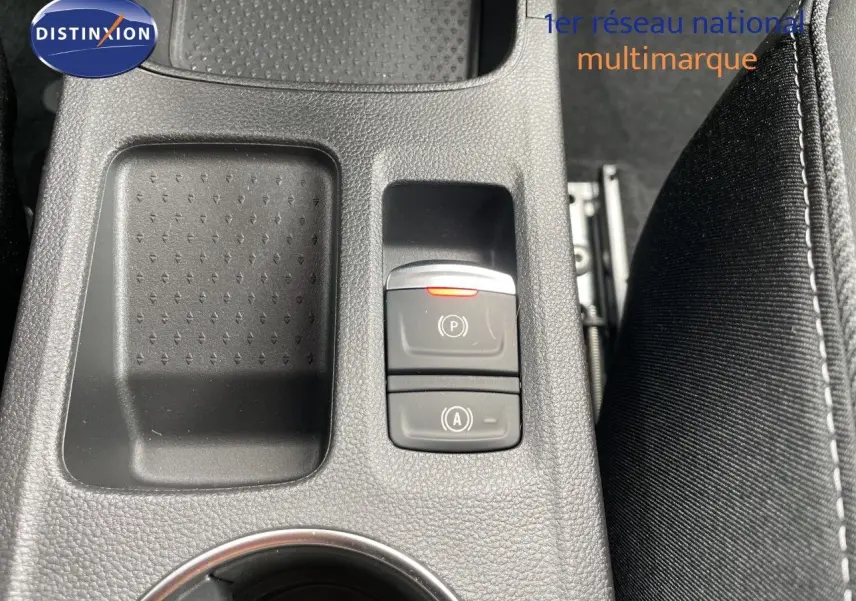 Gros plan sur la console centrale intérieure de la Renault Symbioz gris cassiopée, avec boutons de frein à main et auto hold.