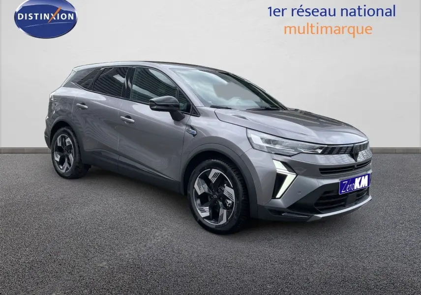 Renault Symbioz gris cassiopée métal en 3/4 avant droit, avec jantes modernes et calandre distinctive.