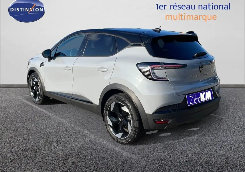 Renault Captur E-Tech hybride 2025 gris rafale métal, vue 3/4 arrière côté gauche avec toit noir et jantes noires.