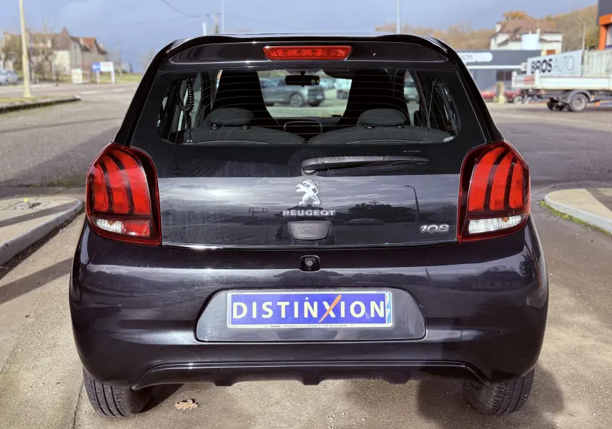 Vue arrière d'une Peugeot 108 noire de 2018, avec feux arrière distinctifs et plaque d'immatriculation DISTINXION.