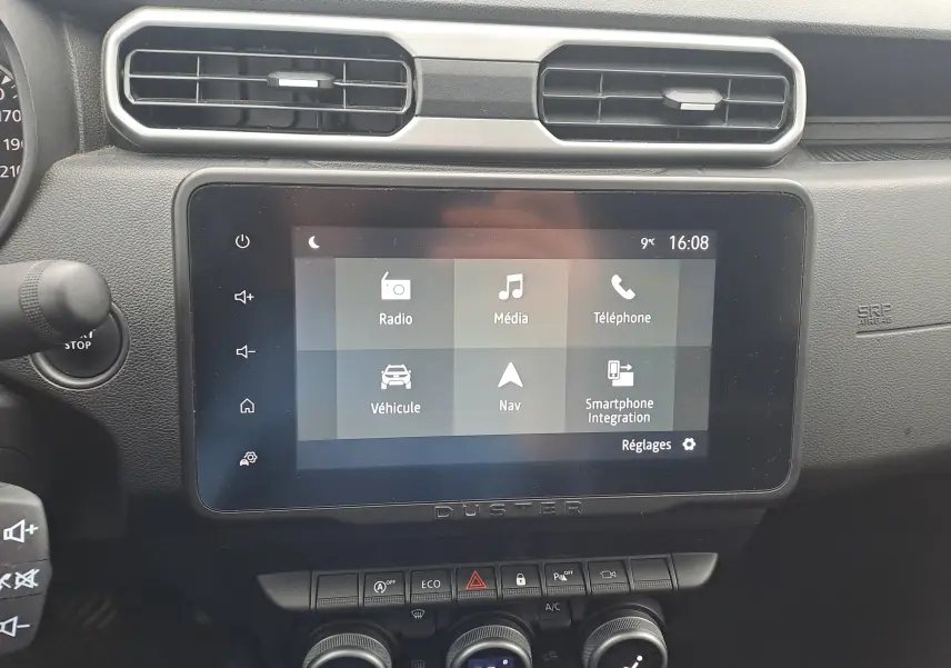 Vue rapprochée de l’écran tactile central et de la console du tableau de bord du Dacia Duster 2023, intérieur noir.