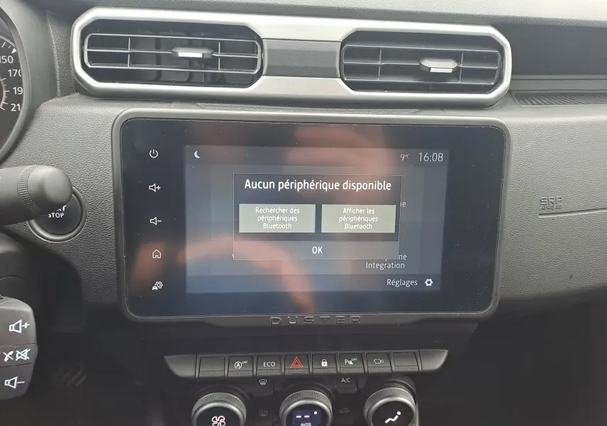 Vue rapprochée de l’écran tactile central du Dacia Duster 2023 avec affichage Bluetooth et tableau de bord noir.