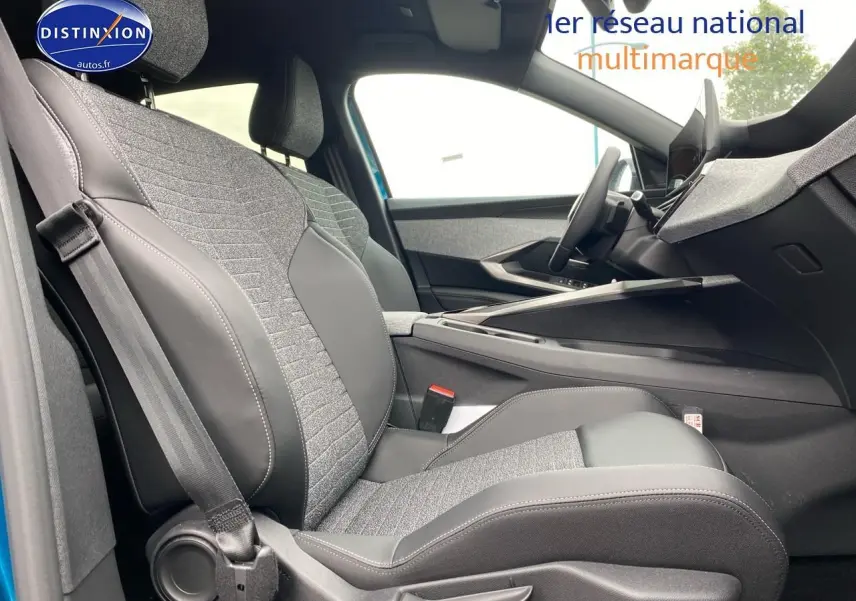 Vue intérieure côté conducteur du Peugeot 3008 bleu 2025, mettant en valeur les sièges tissu et cuir gris avec coutures apparentes.
