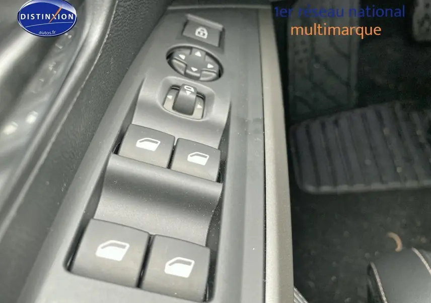 Gros plan sur les commandes de lève-vitres et rétroviseurs côté conducteur du Peugeot 3008 bleu, intérieur noir.
