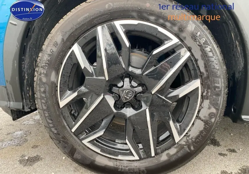 Gros plan sur la jante alu noire et argentée d’un Peugeot 3008 bleu, vue côté droit avec pneu Michelin.