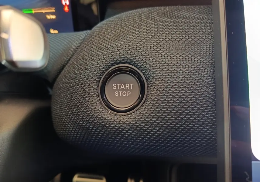 Gros plan sur le bouton Start/Stop intégré dans un habillage texturé noir à l'intérieur du Citroën C5 Hybride 2026.