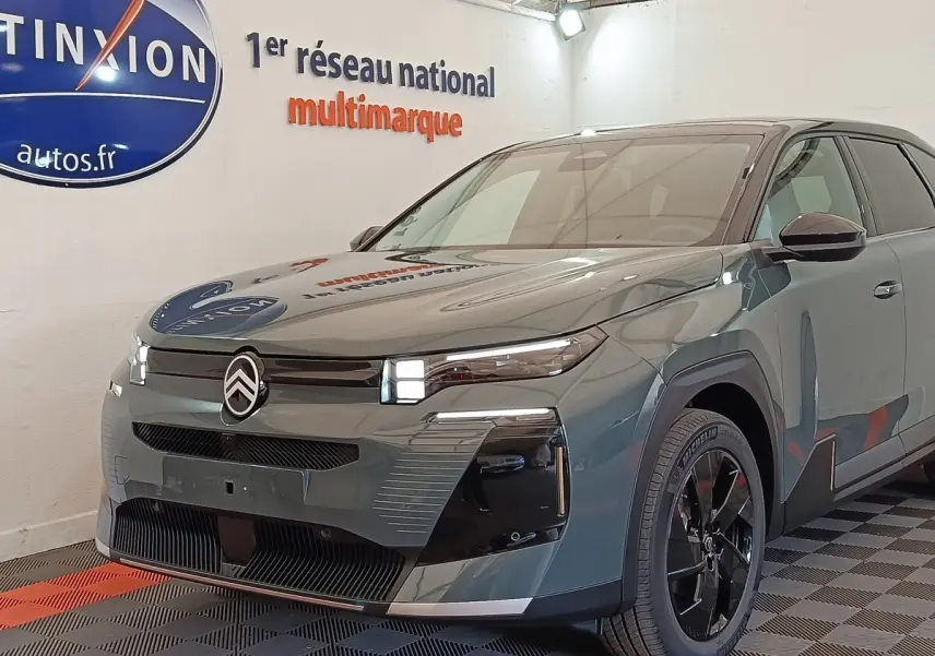 Vue 3/4 avant d'une Citroën C5 hybride 2026 vert foncé avec phares LED et jantes noires brillantes.