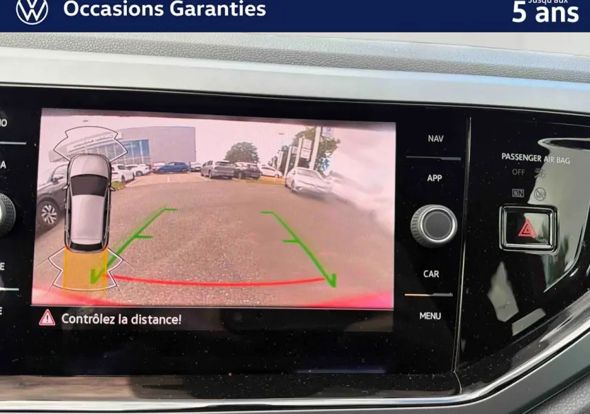 Écran tactile de la Volkswagen Polo rouge montrant la caméra de recul avec guidage dynamique en vue arrière.
