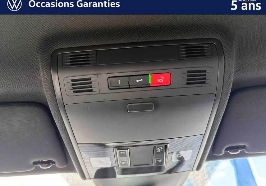 Vue intérieure en gros plan du plafonnier avec commandes d’éclairage et bouton SOS de la Volkswagen Polo rouge 2025.