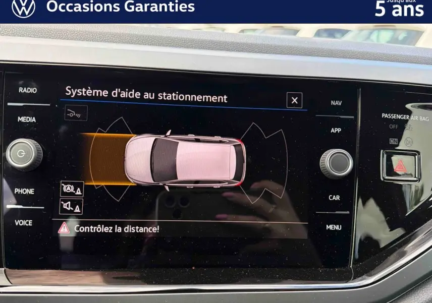 Écran tactile intérieur affichant le système d'aide au stationnement de la Volkswagen Polo 2025 en vue de dessus du véhicule.