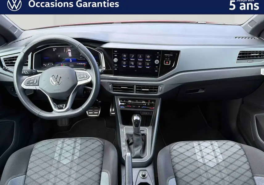 Vue intérieure avant du tableau de bord et volant cuir multifonctions d'une Volkswagen Polo 2025 avec levier de vitesse et écran tactile central.