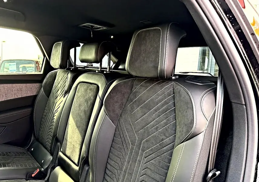 Vue intérieure côté droit montrant les sièges arrière en cuir noir avec surpiqûres contrastantes du Peugeot 5008 Hybrid 145 GT.