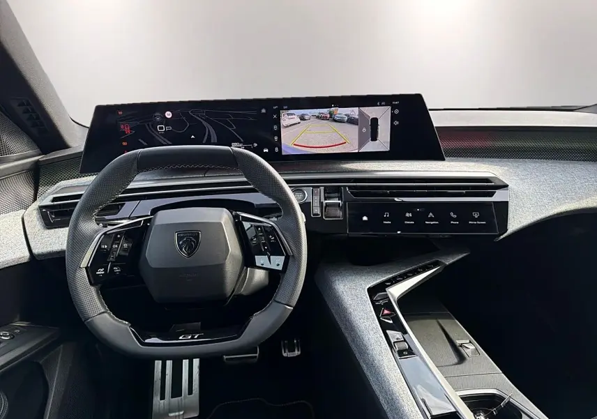 Vue intérieure du tableau de bord du Peugeot 5008 Hybrid 145 GT, avec volant cuir multifonction et écran tactile panoramique.