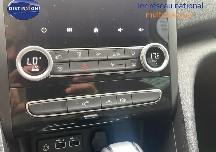 Gros plan sur la console centrale de la Renault Mégane Break 2024, avec commandes climatisation et boîte automatique visible.