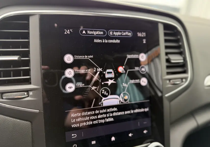 Écran tactile du système d’aide à la conduite de la Renault Mégane Break 2024 affichant alertes et réglages à 24°C.