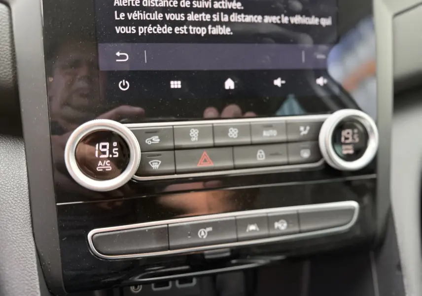 Détail du tableau de bord de la Renault Mégane Break 2024, affichant la climatisation à 19,5°C sur un écran tactile noir.