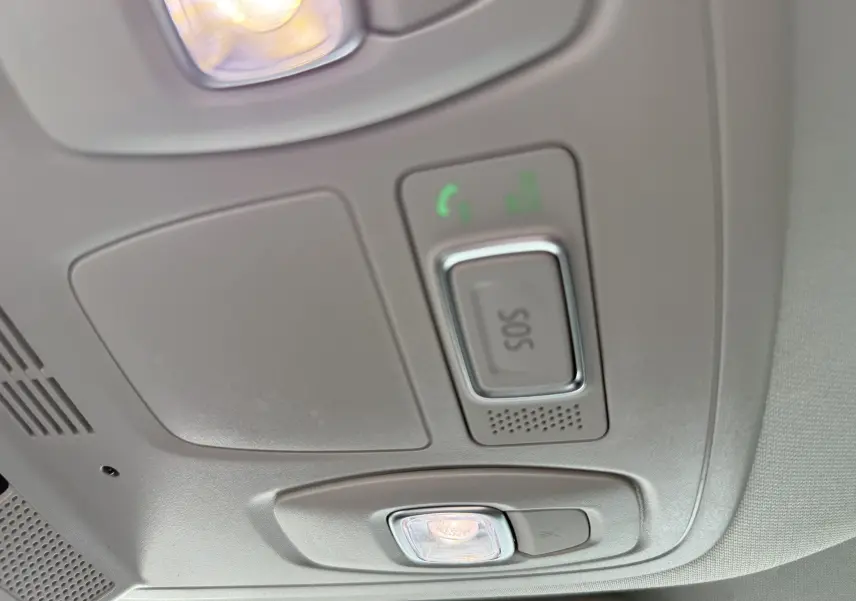 Plafonnier intérieur avec bouton SOS et éclairage, détail du toit d'une Renault Mégane Break gris Highland Metal 2024.