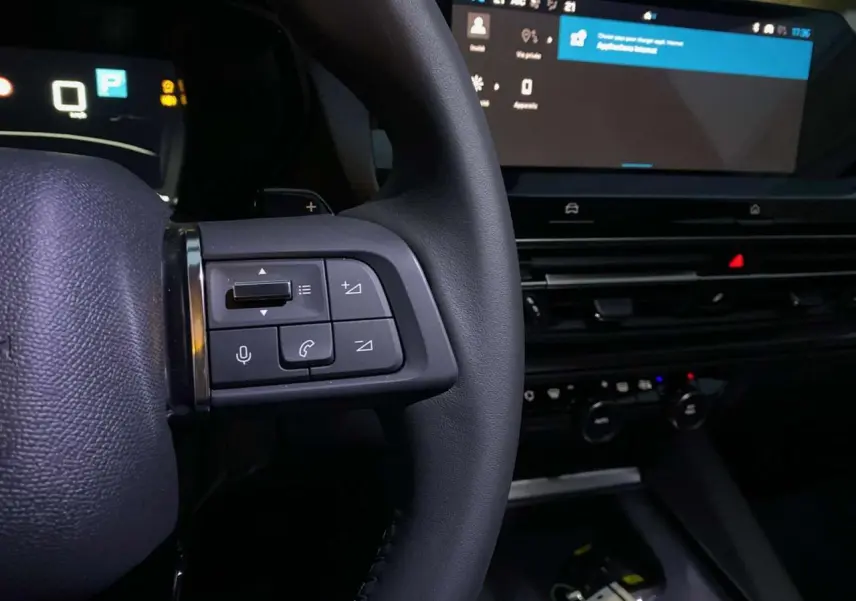 Gros plan sur la partie gauche du volant et le tableau de bord numérique du Citroën C5 X 2023 avec écran tactile et commandes intégrées.