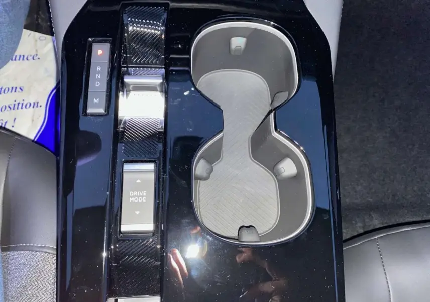 Vue rapprochée du sélecteur de boîte automatique et porte-gobelets noirs brillants de la Citroën C5 X 2023.