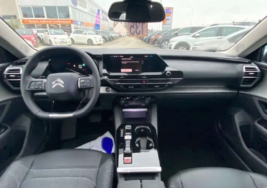 Vue intérieure avant du Citroën C5 X 2023, tableau de bord moderne avec écran tactile et volant multifonction noir.
