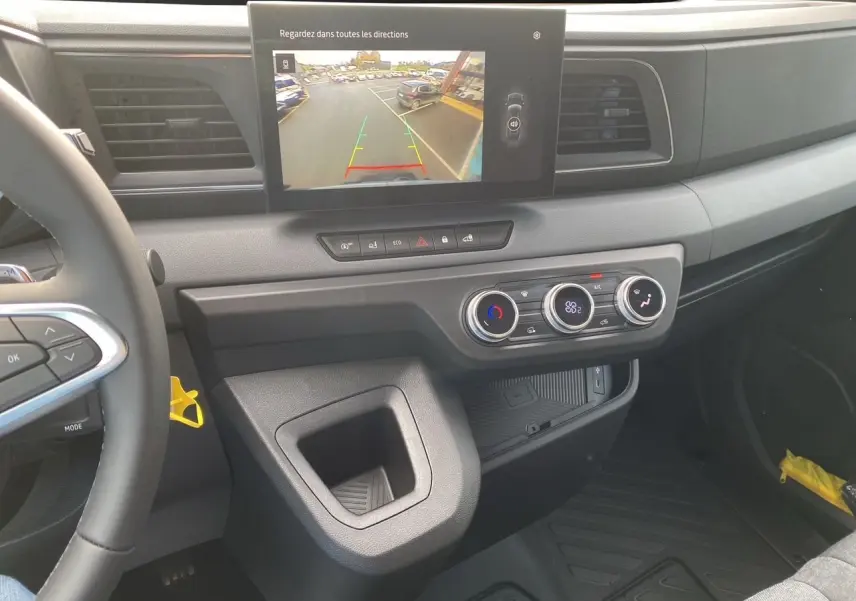 Vue intérieure du tableau de bord du Renault Master 2025 avec écran de recul et commandes de climatisation visibles.