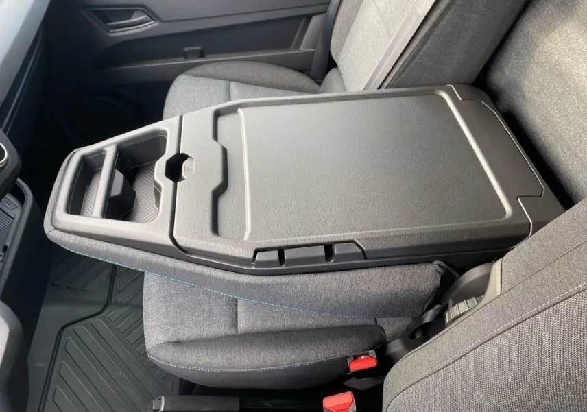 Vue intérieure rapprochée du siège passager gris avec accoudoir central et tablette rabattable du Renault Master 2025.