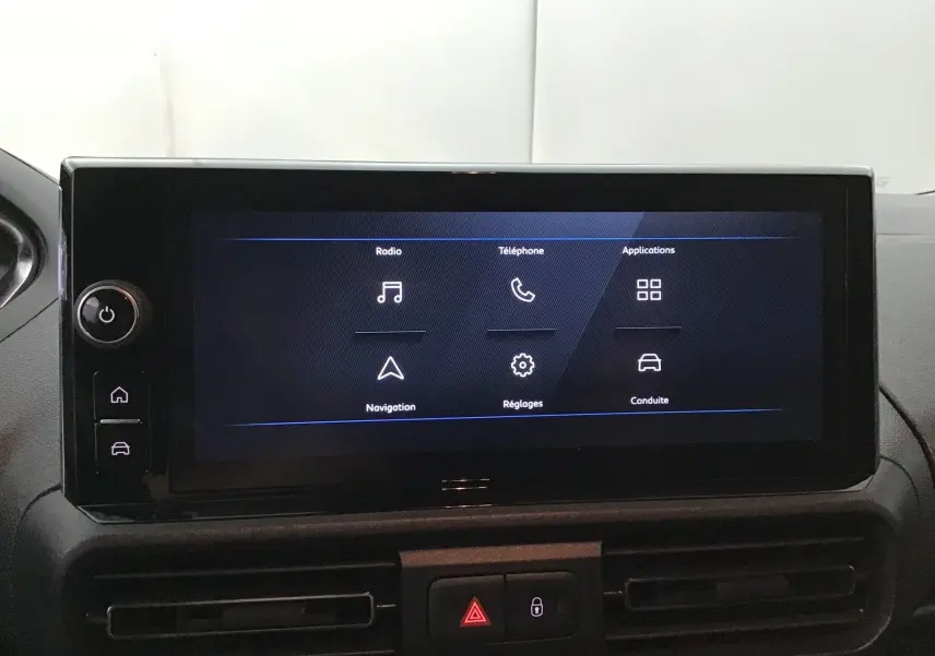 Écran tactile central du tableau de bord du Peugeot Partner 2025 affichant les options radio, téléphone, navigation et réglages.