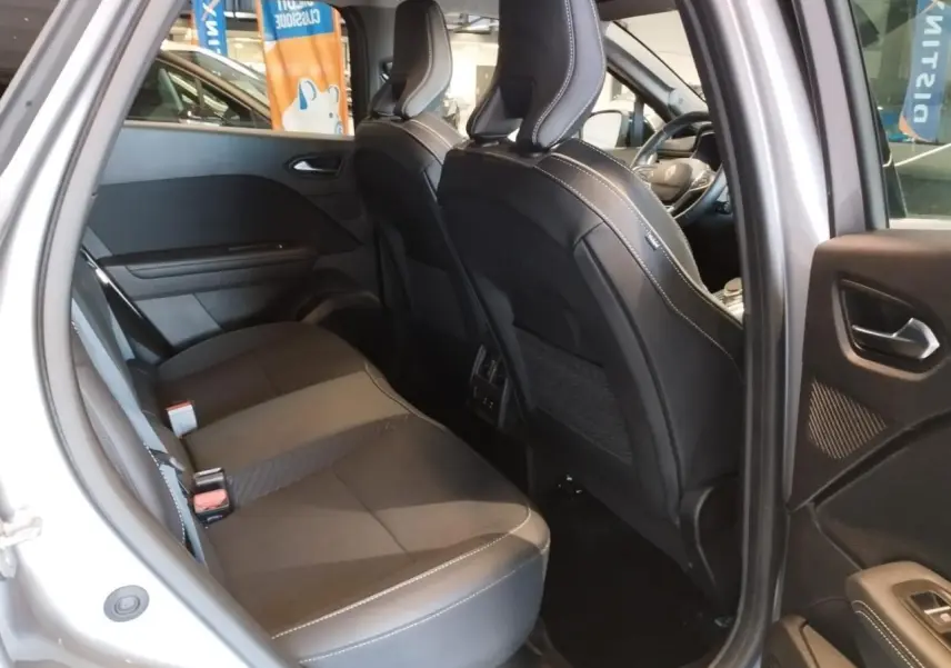 Vue intérieure côté droit sur la banquette arrière et les sièges avant en cuir noir du Renault Symbioz gris Cassiopée 2025.