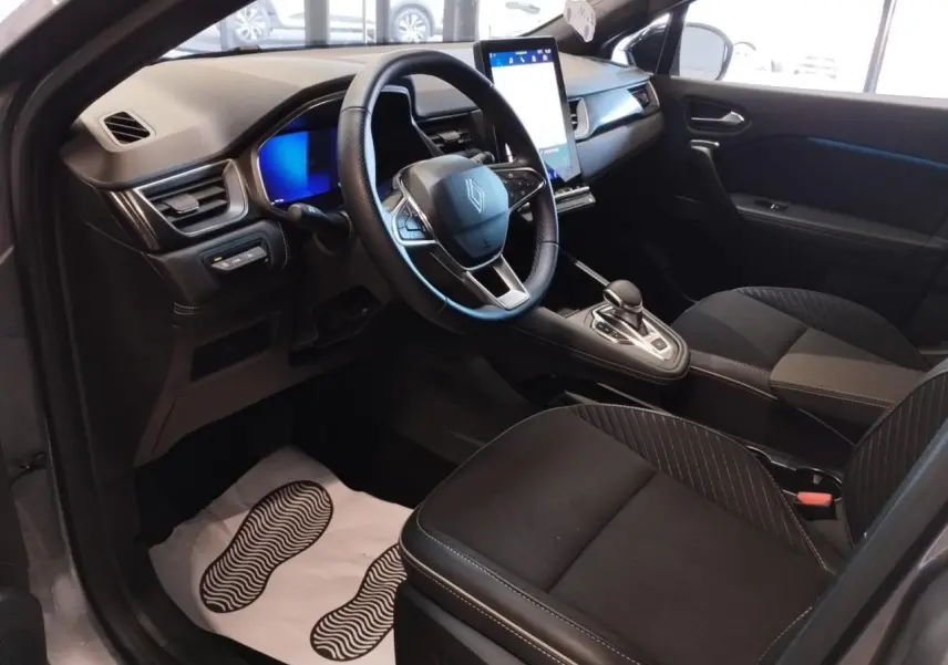 Vue intérieure côté conducteur du Renault SYMBIOZ gris Cassiopée, avec tableau de bord numérique et écran tactile vertical.
