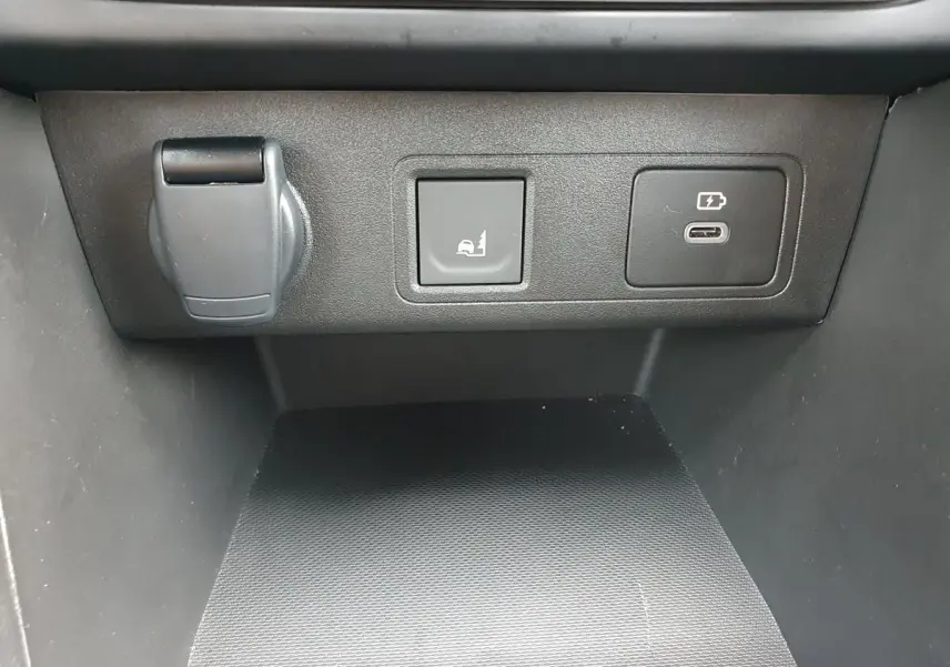 Détail du tableau de bord avec prise USB-C et bouton rabattement banquette du Dacia Jogger vert cèdre.