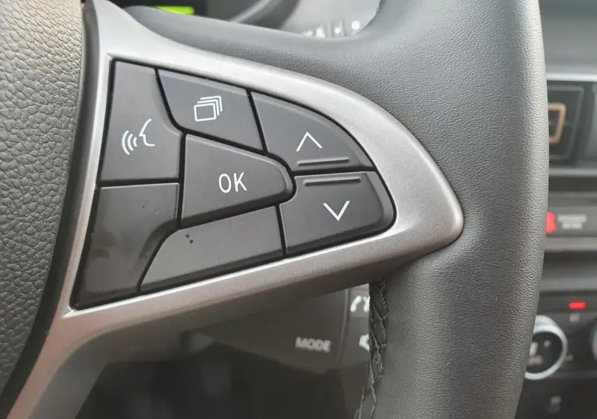 Gros plan sur les commandes multifonctions à gauche du volant du Dacia Jogger, intérieur noir.