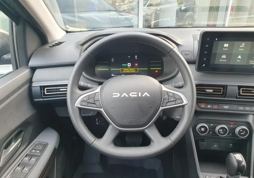 Vue intérieure centrée sur le volant DACIA du Jogger 2026 avec tableau de bord numérique et écran tactile.
