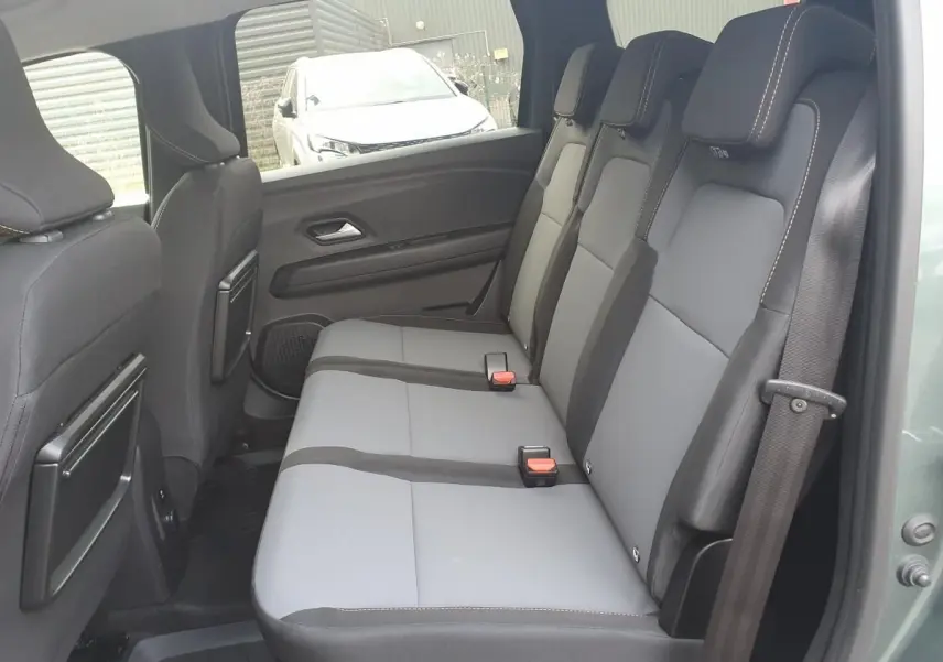 Vue latérale droite de la banquette arrière grise et noire du Dacia Jogger 2026 vert cèdre, avec ceinture de sécurité visible.