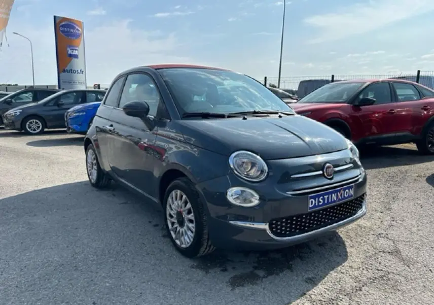 Fiat 500C gris avec toit rouge vue 3/4 avant droit, capote fermée, sur parking en extérieur.
