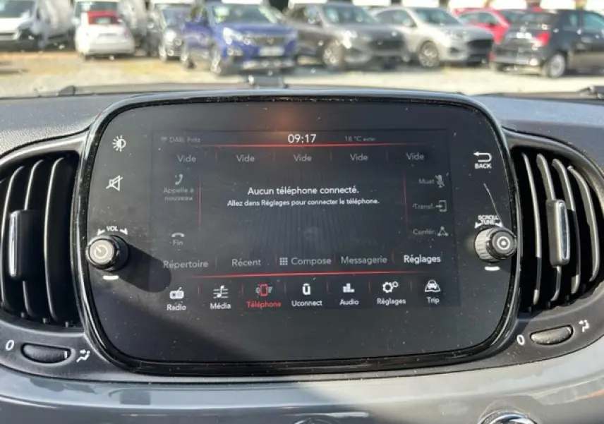 Écran tactile central de la Fiat 500C gris/rouge, affichant le menu téléphone avec commandes autour.