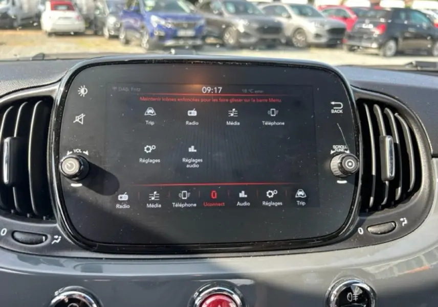 Écran tactile central du tableau de bord de la Fiat 500C 2021, avec commandes multimédia et aérateurs latéraux noirs.