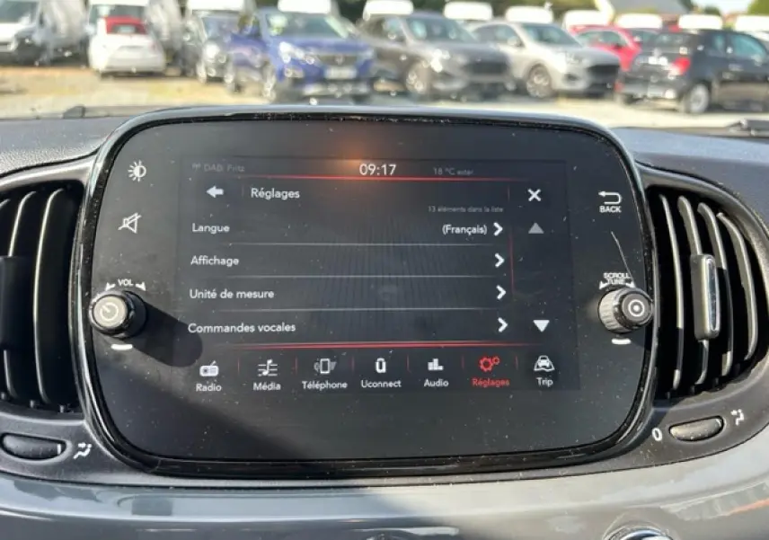 Vue rapprochée de l'écran tactile central du tableau de bord gris d'une Fiat 500C cabriolet, affichant le menu Réglages.