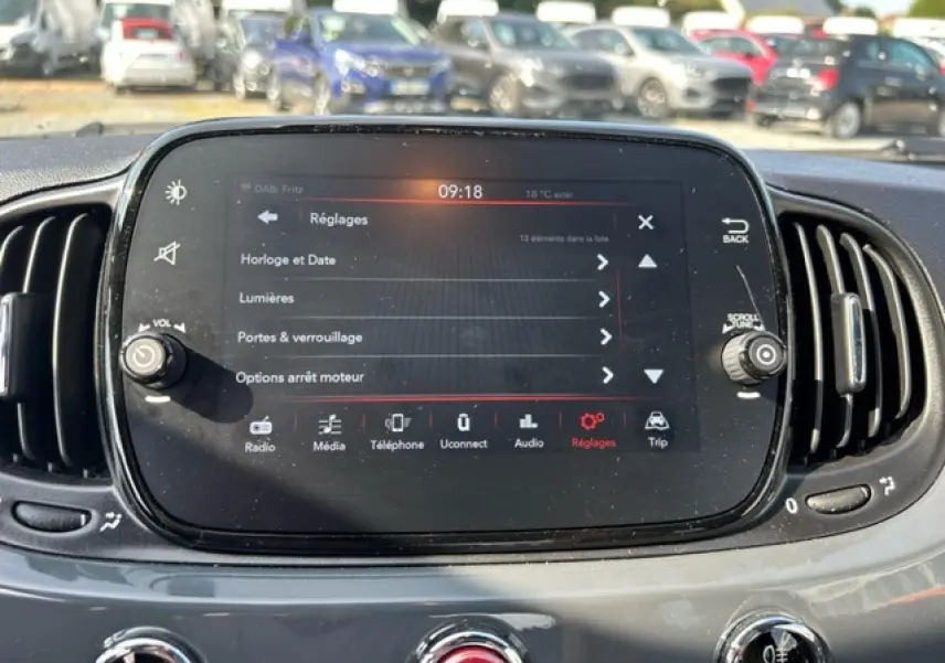 Vue rapprochée de l'écran tactile central du tableau de bord gris du Fiat 500C cabriolet, avec commandes visibles.
