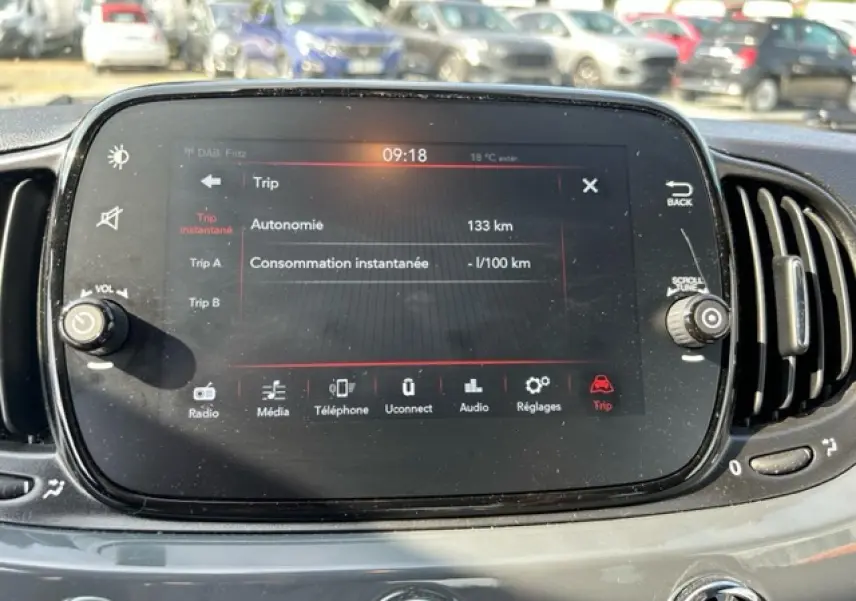 Écran tactile central de la FIAT 500C gris/rouge affichant les informations de trajet et la température extérieure.