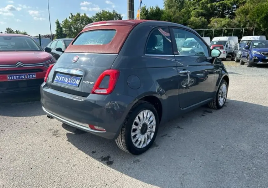 Fiat 500C gris avec capote rouge vue 3/4 arrière droit, soulignant son toit cabriolet fermé et ses jantes distinctives.